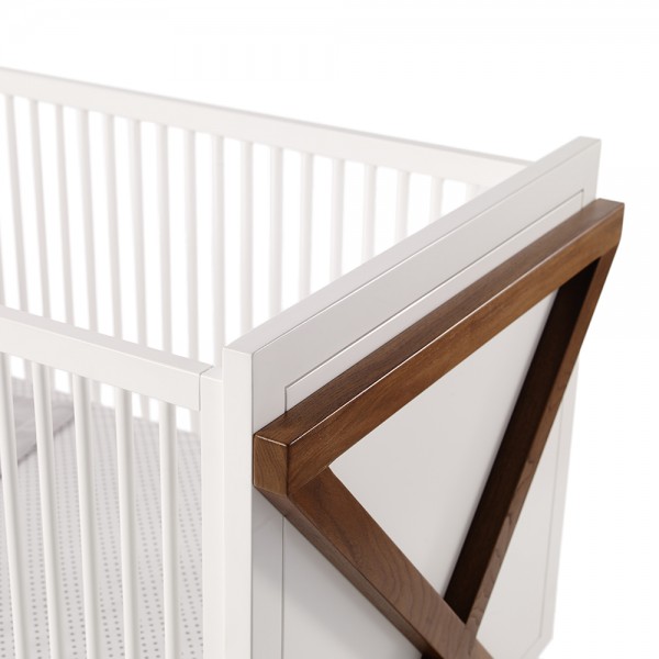 white crib with wood x on side